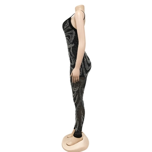 Detail view of the intricate silver rhinestone geometric patterns on the black mesh jumpsuit
