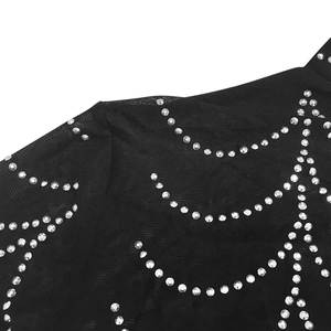 Macro detail of sexy black mesh dress with glittering silver rhinestones in wavy patterns