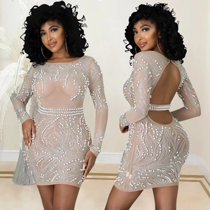 Dettaglio di un abito attillato in rete nude con perle, strass ed elegante scollatura