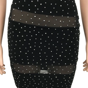 Close-up of silver studs and semi-transparent mesh panels on black bodycon dress