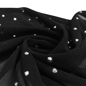 Close-up of black mesh fabric with sparkling silver rhinestones for sexy evening dress