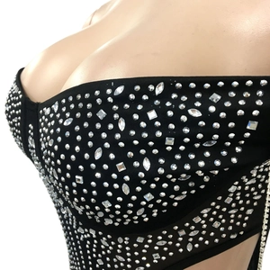 Detailed close-up of a black corset top with shimmering rhinestones in various shapes