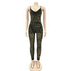 Detail of black mesh jumpsuit featuring intricate gold rhinestone swirls and sheer panels