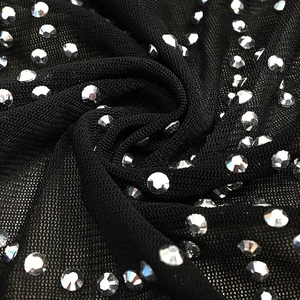 Close-up of black mesh fabric with sparkling silver rhinestones for evening dresses