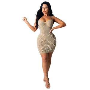 Detail of champagne bodycon dress featuring rhinestone and pearl radial patterns