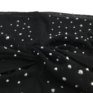 Detail view of black mesh fabric with sparkling silver rhinestones for a sexy dress