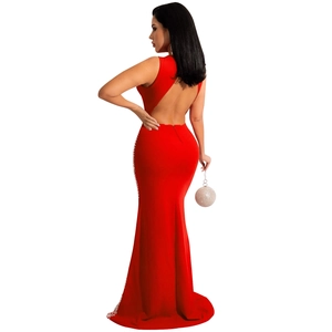 Detail of red backless evening dress with rhinestone embellishments and silver sphere bag
