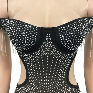 Close-up of black bodysuit with shimmering rhinestones, cut-outs and fringe sleeve details