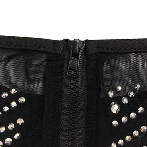 Detail of mesh fabric with sparkling rhinestones and black zipper closure on dress