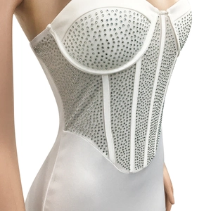 Detail of white corset bodysuit with shimmering silver rhinestones and structured boning