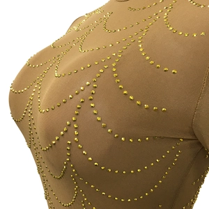Close-up of mesh see-through dress with intricate golden rhinestones in wavy patterns