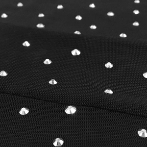 Macro detail of sparkling rhinestones on black mesh fabric for sexy evening dresses