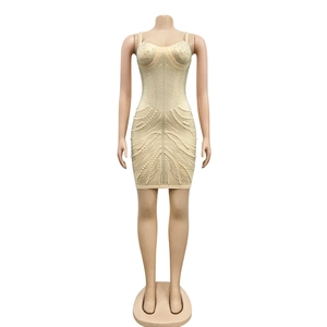 Detailed view of champagne mini dress with sweetheart neckline, pearls, and rhinestones