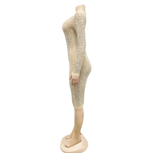 Detail of nude mesh dress featuring wave-patterned white pearls and sparkling rhinestones