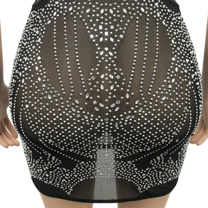 Detailed view of high-density rhinestones on black mesh see-through dress fabric