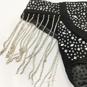 Detail view of black mesh fabric with sparkling rhinestones and silver tassel chains