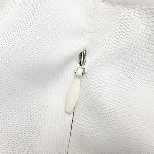 Detailaufnahme eines weißen verdeckten Reißverschlusses an einem strukturierten Kleid