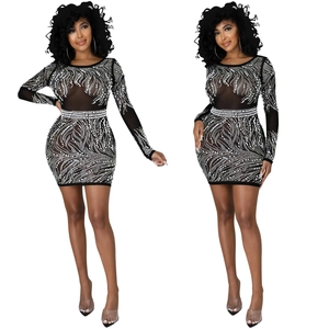 Dettaglio di un abito sexy in mesh per feste con strass scintillanti e maniche lunghe