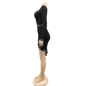 Detail eines sexy schwarzen figurbetonten Kleides mit Strassakzenten und asymmetrischem Saum