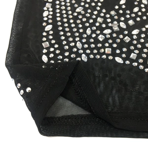 Macro detail of black mesh dress featuring silver rhinestones and fine stitching craft