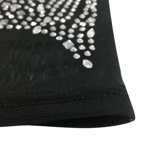 Detail of black mesh fabric featuring intricate rhinestones and double-needle stitching