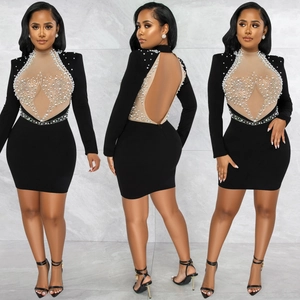 Detail of elegant black dress showing intricate pearls and rhinestones on mesh panel