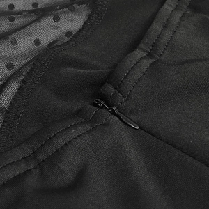 Detail of invisible zipper on black mesh dress with polka dot patterns and neat stitching