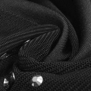 Macro detail of black sheer mesh fabric with sparkling rhinestones on the long dress