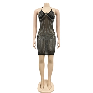 Détail de la robe moulante en maille noire avec strass argentés et tissu transparent chic