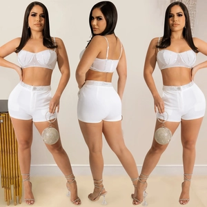 Front and back views of white rhinestone crop top and high-waisted shorts set