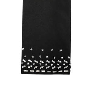 Detailaufnahme von schwarzem Strickstoff mit dreireihigem silbernem Strasssteinbesatz
