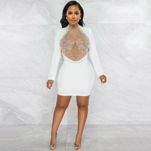 Detailed view of white bodycon dress featuring sheer mesh with pearls and rhinestones