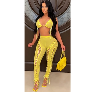 Close-up of bright yellow mesh two-piece set featuring cross-strap details and eyelets