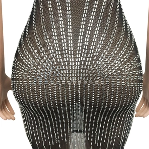 Détail d'une robe en résille noire ornée de strass argentés en motif étoilé