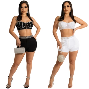Detail of two-piece women set featuring rhinestone crop top and high-waisted shorts