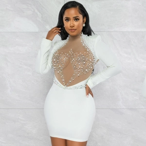 Detail of white bodycon dress featuring sheer mesh with pearls and rhinestone accents
