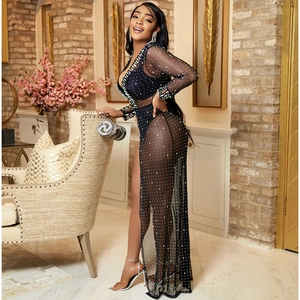 Close-up of black mesh maxi dress with silver rhinestones and high slit for parties