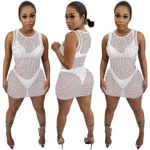 Detail of white mesh mini dress with sequins, rhinestones and faux pearl embellishments