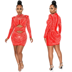 Detail of red rhinestone mini dress featuring waist cut-outs and shimmering crystal patterns