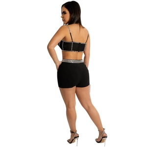 Detail of black two-piece set with rhinestone trim on crop top and high-waist shorts