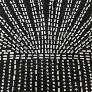 Gros plan détaillé de strass argentés sur tissu en maille noire pour robe sexy