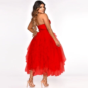 Detail of red strapless dress featuring layered tulle ruffles and voluminous mesh skirt