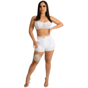 Detail of white two-piece set featuring rhinestone embellished corset top and matching shorts
