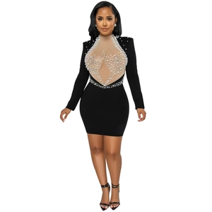 Detail of mesh bodice with faux pearl embellishments on a black long sleeve mini dress