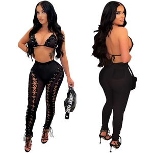 Detail of black mesh two-piece set featuring hollow-out lace-up sides and metal rings