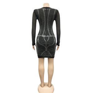 Macro detail of the back view of a sheer black bodycon dress with sparkling silver rhinestones