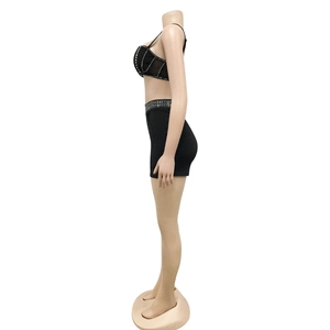 Side view of black two-piece set with silver rhinestones on crop top and mini skirt