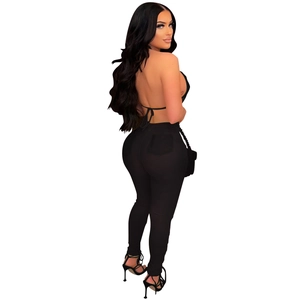 Detail of a sexy black backless halter top and high waisted skinny trousers set