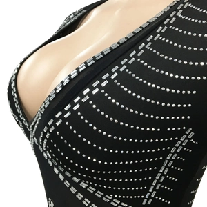 Detail of deep V-neck black mesh dress with intricate silver rhinestone geometric patterns