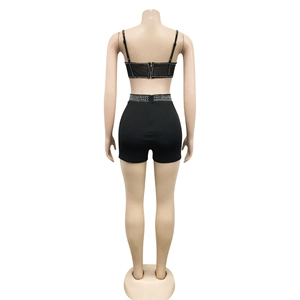 Detail view of the back zipper and rhinestone trim on black two-piece set for women